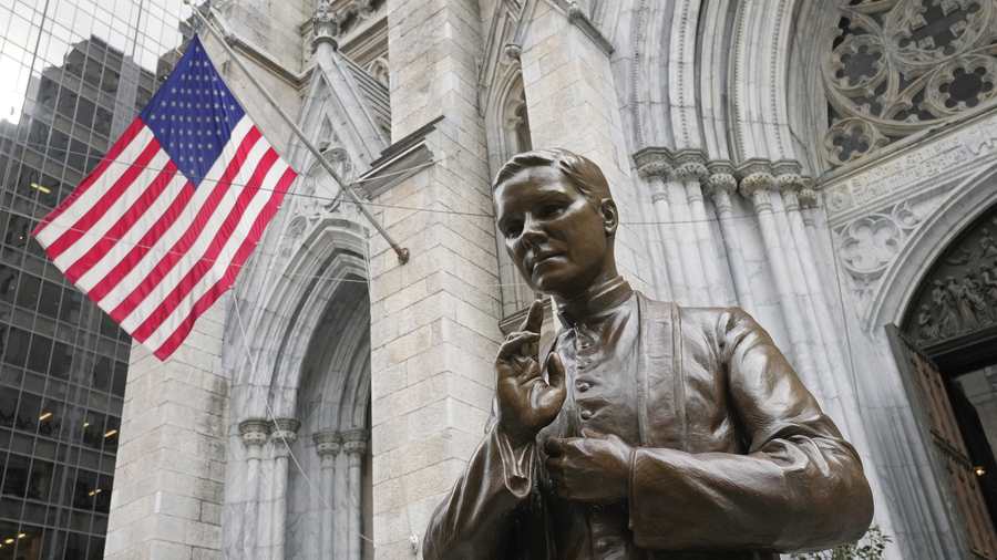 A bronze statue of Blessed Michael McGivney in front of St. Patrick's Cathedral