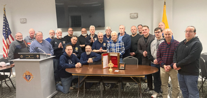 Members of Msgr. William A. Delaney Council 5983 in Farmingdale, N.Y., gather around a relic Blessed Michael McGivney during a recent Cor gathering. 
