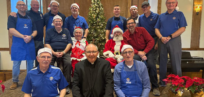 Knights from Perez Council 1176 in Lockport, Ill., and Father Daniel Hoehn, pastor of St. Joseph Parish and a brother Knight, assemble around parishioners portraying Santa and Mrs. Claus during the council’s annual pancake breakfast. 
