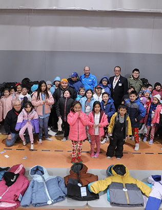 Saskatchewan and New Brunswick Knights of Columbus members unite in charity to distribute close to 600 winter coats for children.