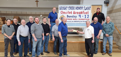 Past Grand Knight Gregg Olson (holding check, left), with other members of Bishop Clement Smith Council 838 in Webster City, Iowa, presents a $4,000 check to Russ Naden, a board member of Brushy Creek Honor Flight.