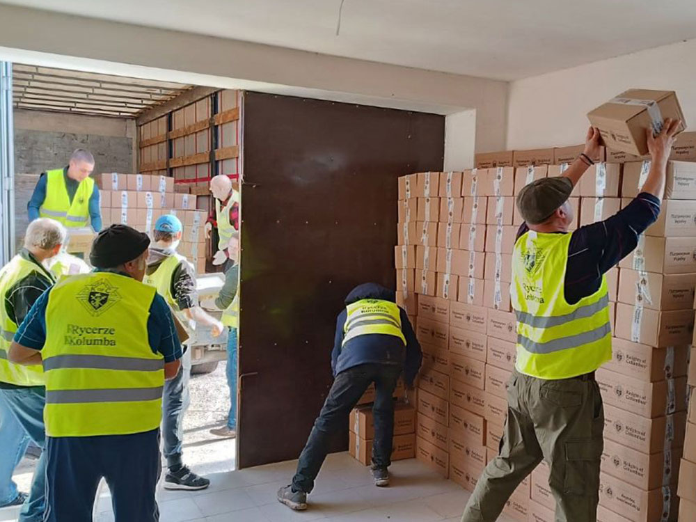 A group of men load food donation boxes onto a truck.