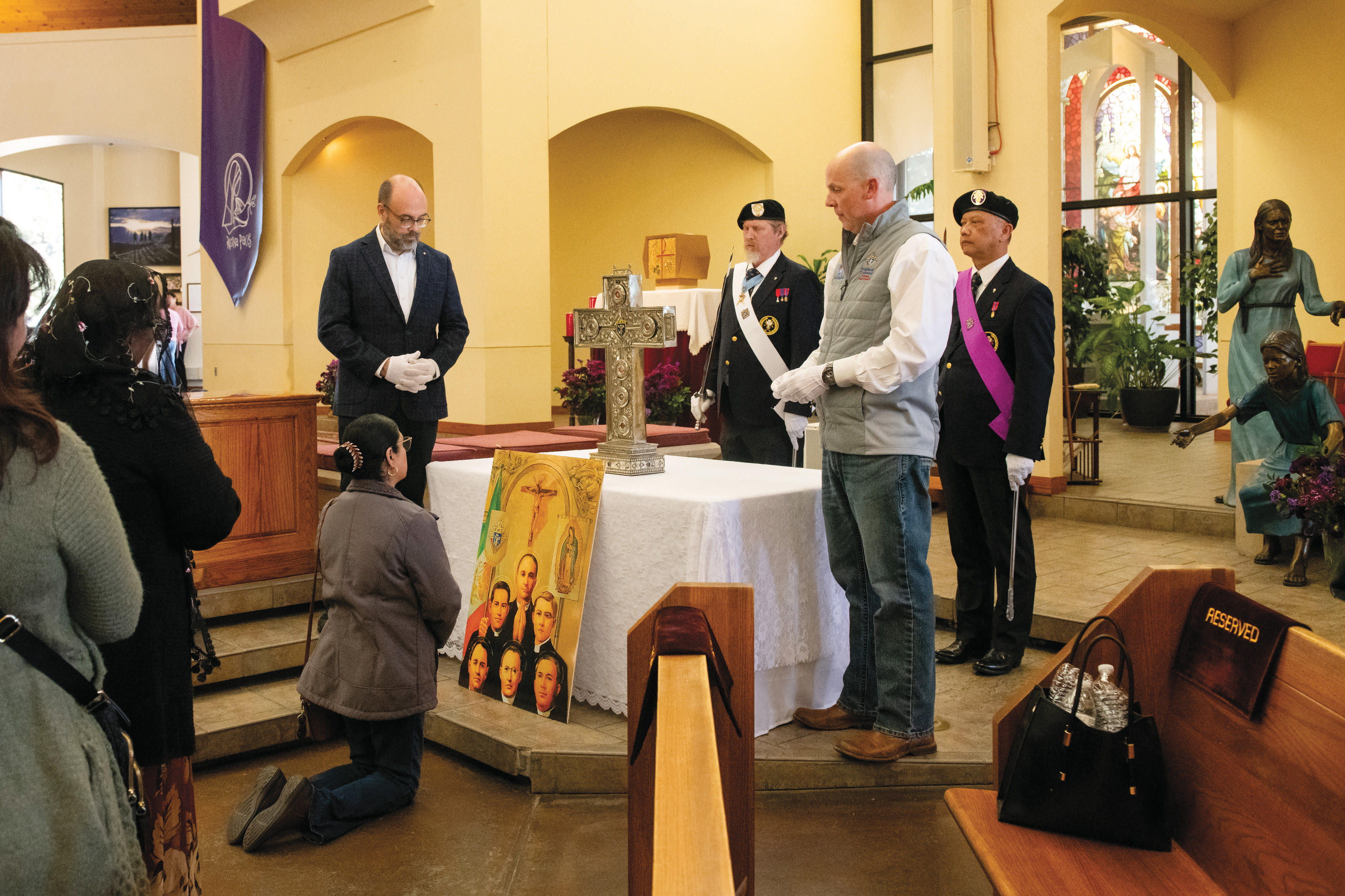 A woman venerates relics of the six Knights of Columbus priest-martyrs at Queen of Peace Catholic Church in Aurora, Colo., on March 8.