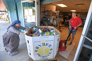Gordon Shellhaas and Servidora Sister Maria de Talpa Vargas Espinoza unload a food shipment at St. Michael Parish in Wauchula.