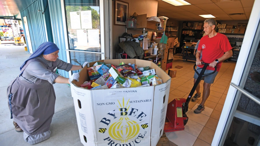 Gordon Shellhaas and Servidora Sister Maria de Talpa Vargas Espinoza unload a food shipment at St. Michael Parish in Wauchula.