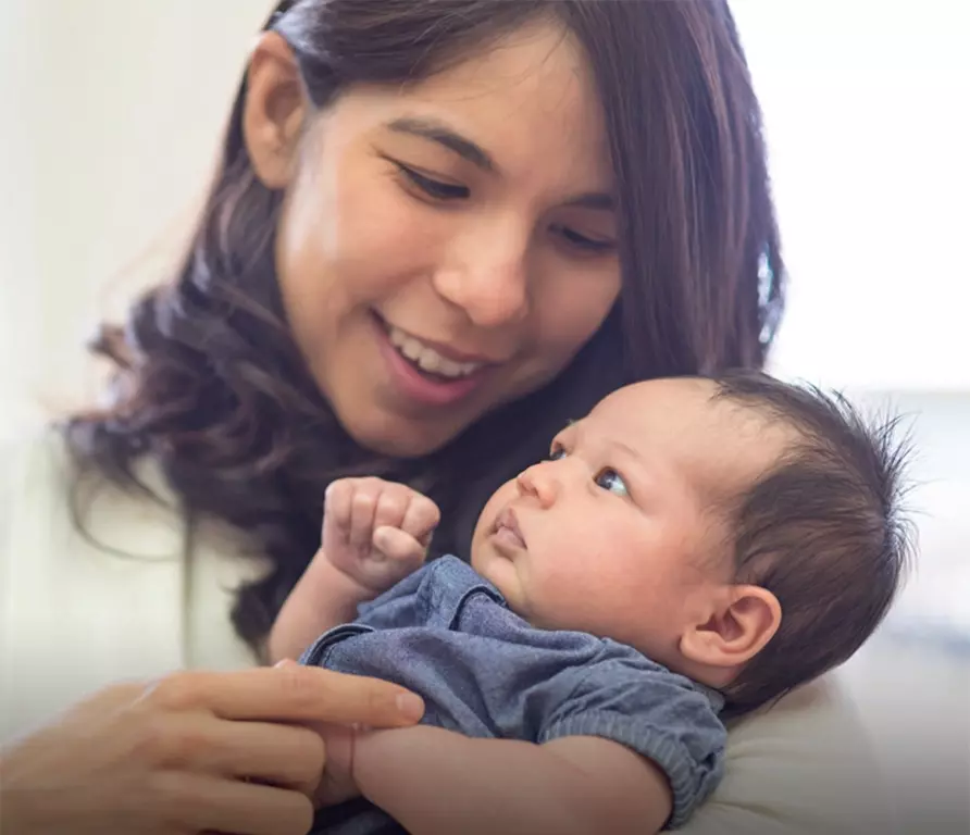 A mother holding her baby in her arms.