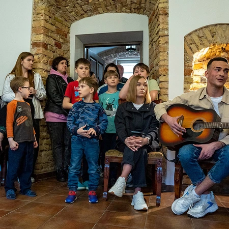 Children and other residents come together for a concert in the hotel. Knights have built community in the residence with activities from concerts to workshops to poetry readings.