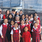 Students and staff members of Holy Innocents School stand before custom-printed fencing screens donated by Msgr. John Cawley Council 3629 in Lakewood, Calif., in 2022.