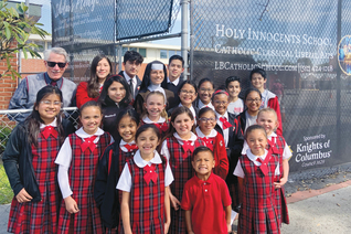 Students and staff members of Holy Innocents School stand before custom-printed fencing screens donated by Msgr. John Cawley Council 3629 in Lakewood, Calif., in 2022.