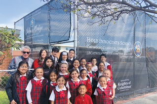 Students and staff members of Holy Innocents School stand before custom-printed fencing screens donated by Msgr. John Cawley
Council 3629 in Lakewood, Calif., in 2022. The screens provide much-needed privacy to the playground of the school, which is
located in a busy urban neighborhood in Long Beach.