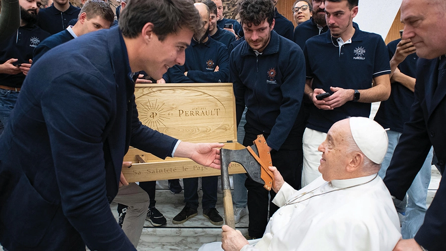 Pope Francis receives an axe from Jean-Baptiste Bonhoure, president of Ateliers Perrault, during an audience at the Vatican.