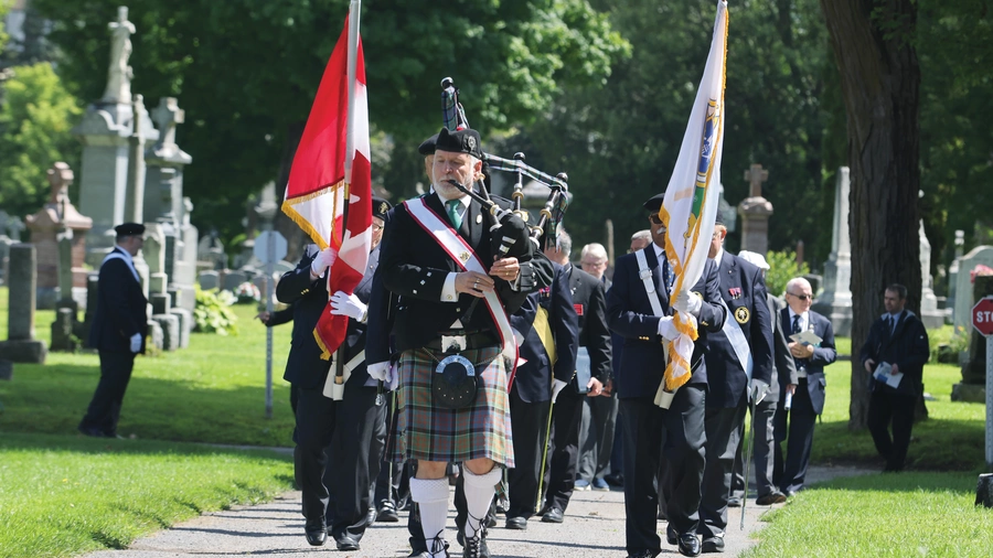 Bagpiper Donald MacDonald, past grand knight of St. Patrick’s Basilica Council 485, leads a Fourth Degree honor guard through Notre Dame Cemetery