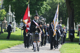 Bagpiper Donald MacDonald, past grand knight of St. Patrick’s Basilica Council 485, leads a Fourth Degree honor guard through Notre Dame Cemetery