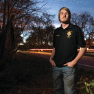 Adam Parzuchowski, 21, stands at the site where he rescued a man from a burning vehicle in June. 