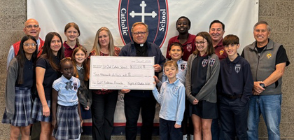 Knights from St. Olaf Council 5502 in Bountiful, Utah, and Father Andrzej Skrzypiec, pastor and council chaplain, present a $10,000 check — proceeds from the council’s annual golf tournament — to Principal Christine Bergquist and students at St. Olaf Catholic School. The funds will help provide the school with supplies, services and new kitchen equipment.