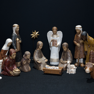 Photo of a painted stone Nativity featuring the Holy Family, Angel, three Magi, two shepherds, a shepherdess, a camel, donkey, ox, two sheep, and a star. 