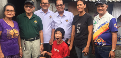 Knights from St. Anne Magarao Council 9027 in Camarines Sur, Luzon South, gather with a boy with disabilities who received a new wheelchair from the jurisdiction’s wheelchair program.