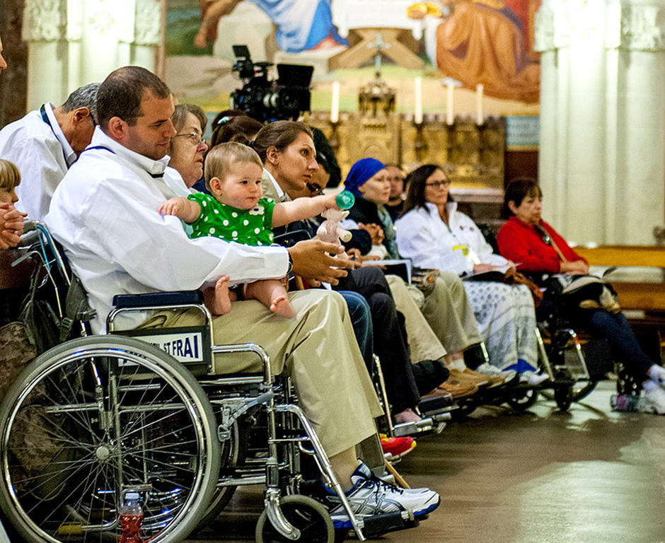People in wheelchairs are attending Mass.