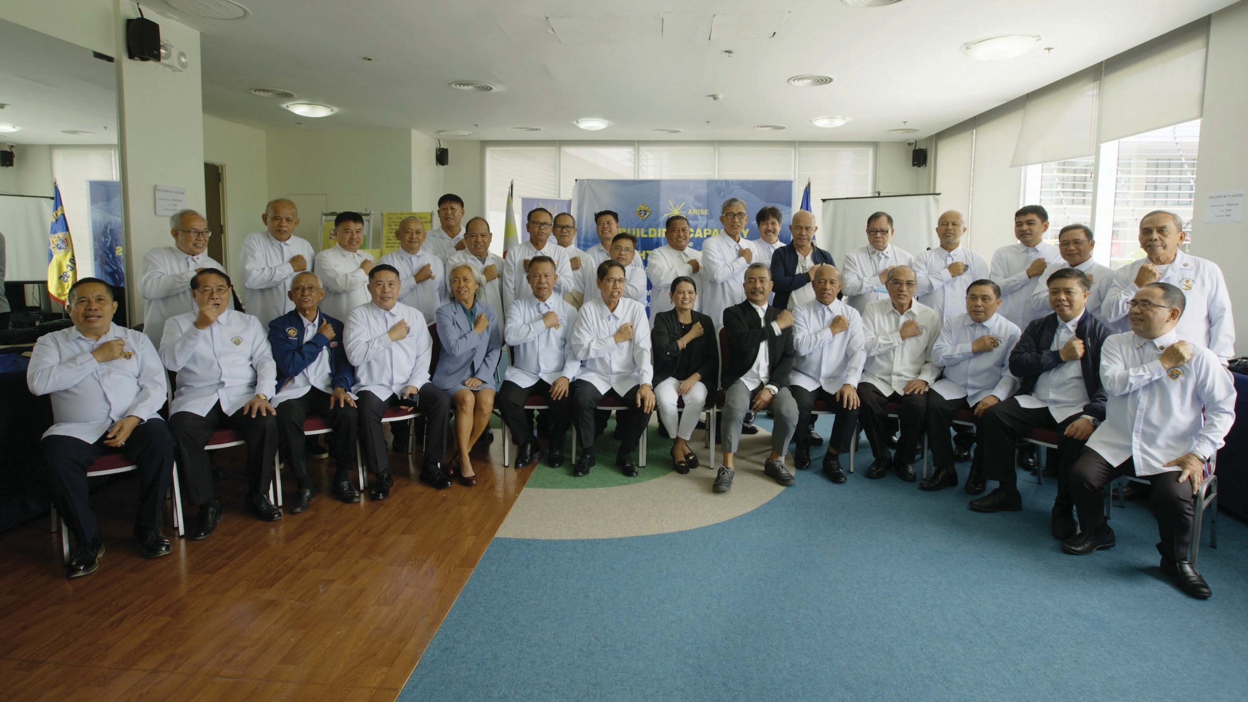 Knights of Columbus leaders and Arise staff members join in a symbolic gesture of solidarity.