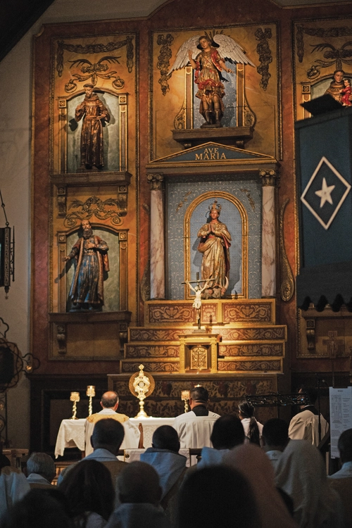 Pilgrims kneel in adoration during a pilgrimage Holy Hour at Mission San Gabriel Arc&aacute;ngel on June 21. 