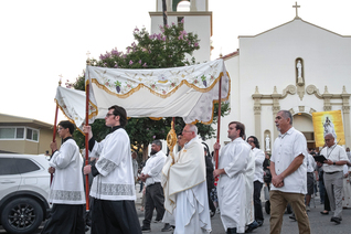 Archbishop José Gomez of Los Angeles carries the monstrance from Sacred Heart Church, leading a Eucharistic procession through Altadena, Calif., on June 20. 