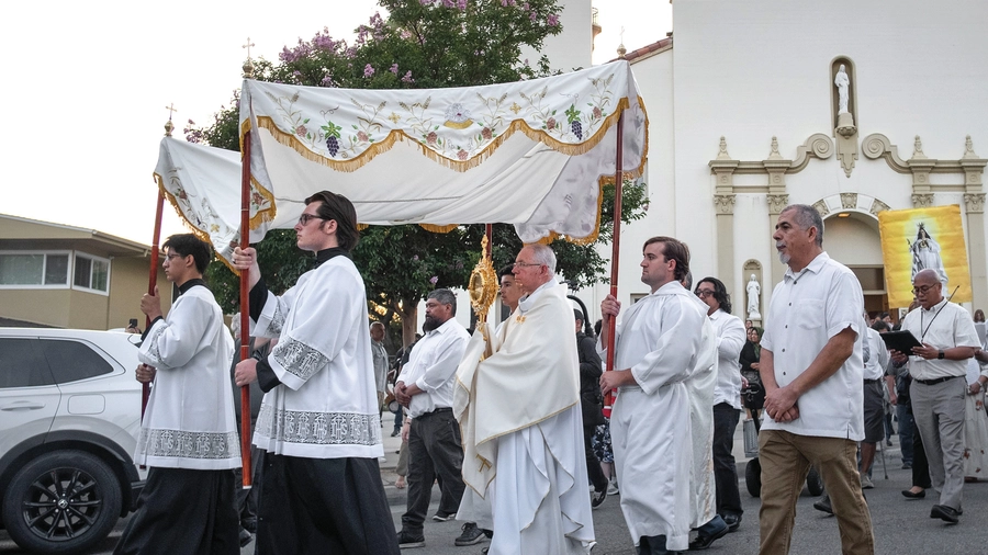 Archbishop José Gomez of Los Angeles carries the monstrance from Sacred Heart Church, leading a Eucharistic procession through Altadena, Calif., on June 20. 