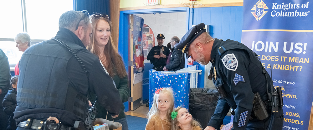 Officers from the Woonsocket Police Department accept toy donations from a family during the annual Ron Auger Toy Drive, which was hosted by the department in collaboration with Woonsocket (R.I.) Council 113 at Good Shepherd Catholic Regional School on Nov. 29.