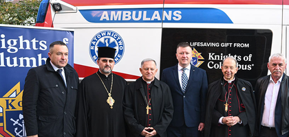 Archbishop William E. Lori visited a cemetery in warn-torn Ukraine with the Knights of Columbus and is pictured with other priests and Knights.