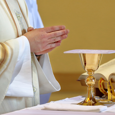 Priest praying with chalice .jpg