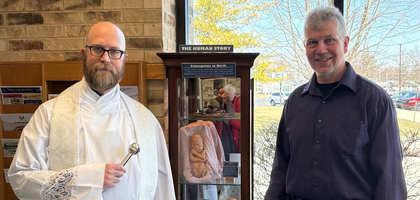 Mark Weiss, life director of Father Aufderheide Council 12912 in Vandalia, Ohio, and Father Kyle Schnippel, pastor of St. Christopher Church, stand beside a pro-life educational display created by the council and the parish respect life committee.