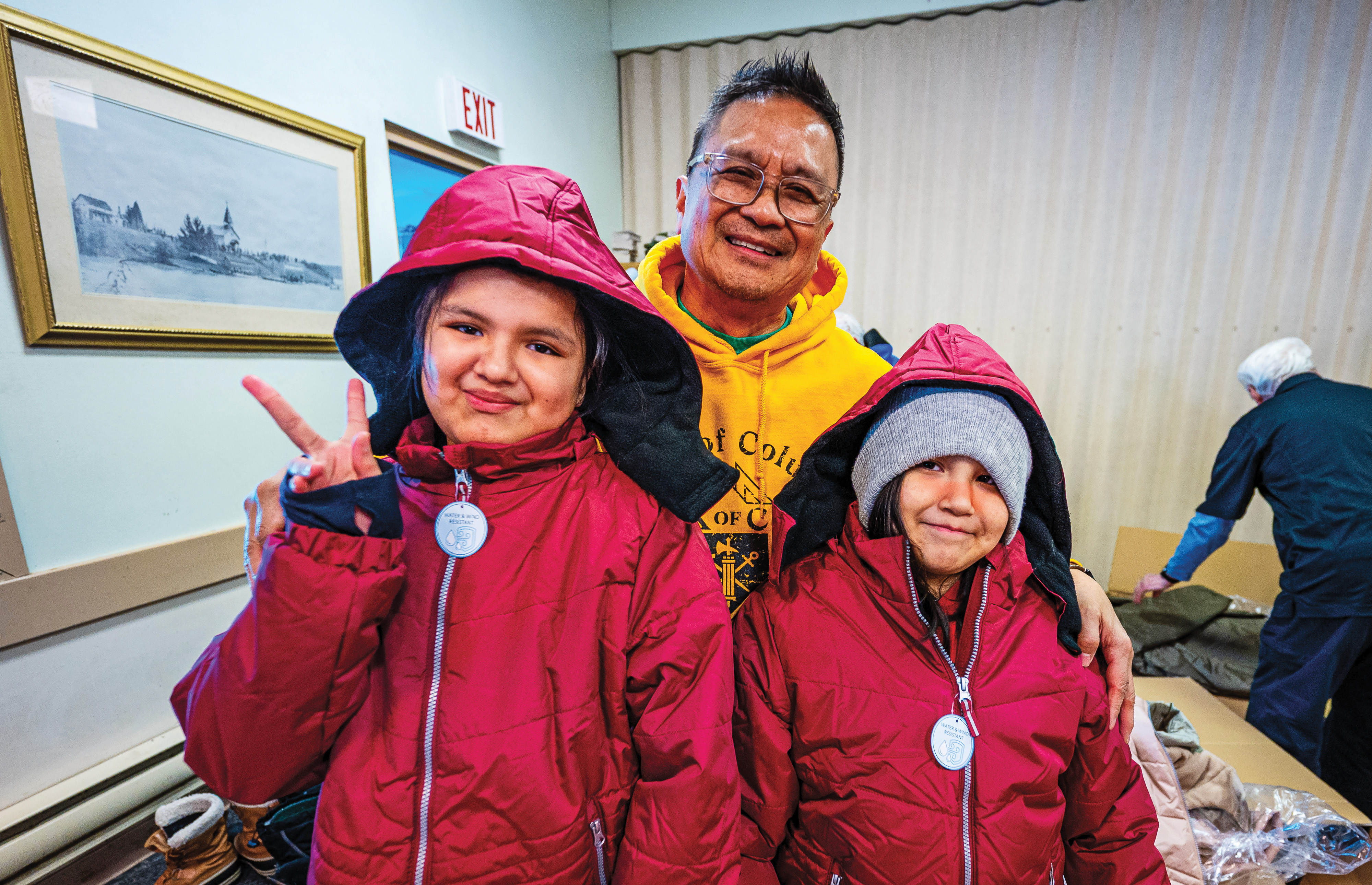 Sisters show off their new winter jackets with help from Cleo Castillo, a Knights of Columbus general agent based in Winnipeg. 