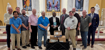 Members of St. Francis Council 11136 in Purcellville, Va., present Father Francline Javlon, a priest of the Diocese of Kumbo and a brother Knight, with 45 Bibles for seminarians of the diocese. 