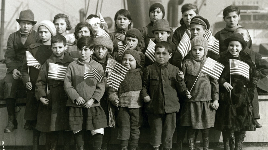 A group of Jewish children orphaned as a result of World War I pose with U.S. flags after arriving to New York City in 1921