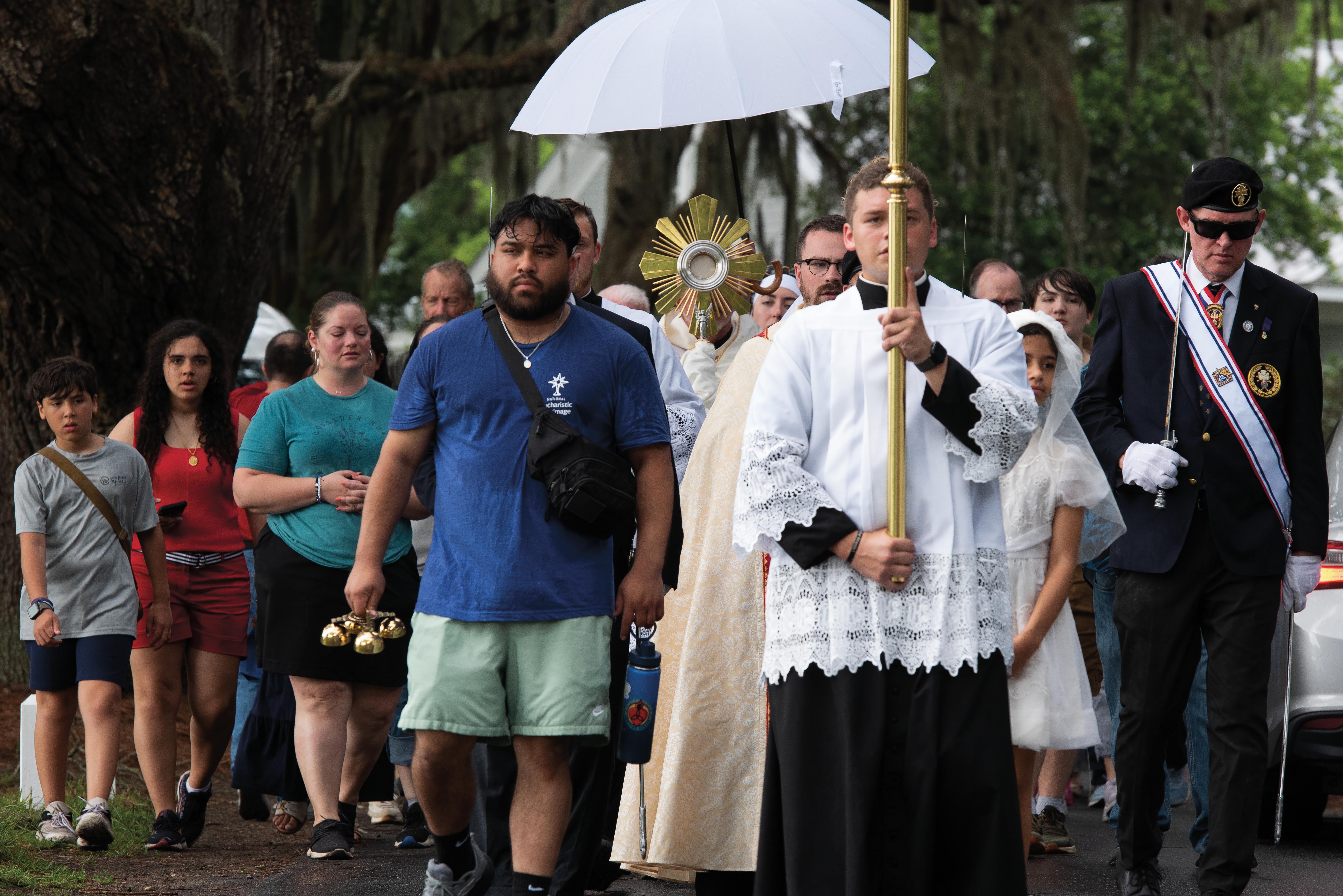 Perpetual pilgrim Raymond Martinez II carries a crucifix at the head of a Eucharistic procession in Savannah, Ga.