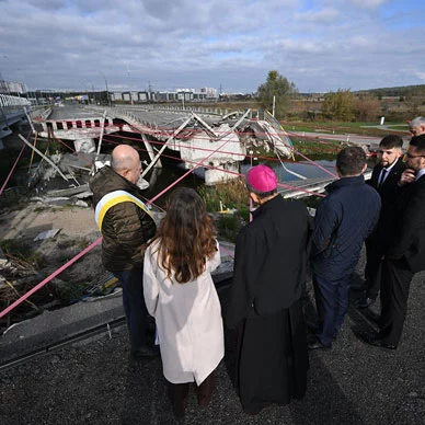 Archbishop William Lori and his delegation visit a destroyed bridge.