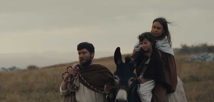 A reenactment of Joseph leading his family on a journey on a donkey.