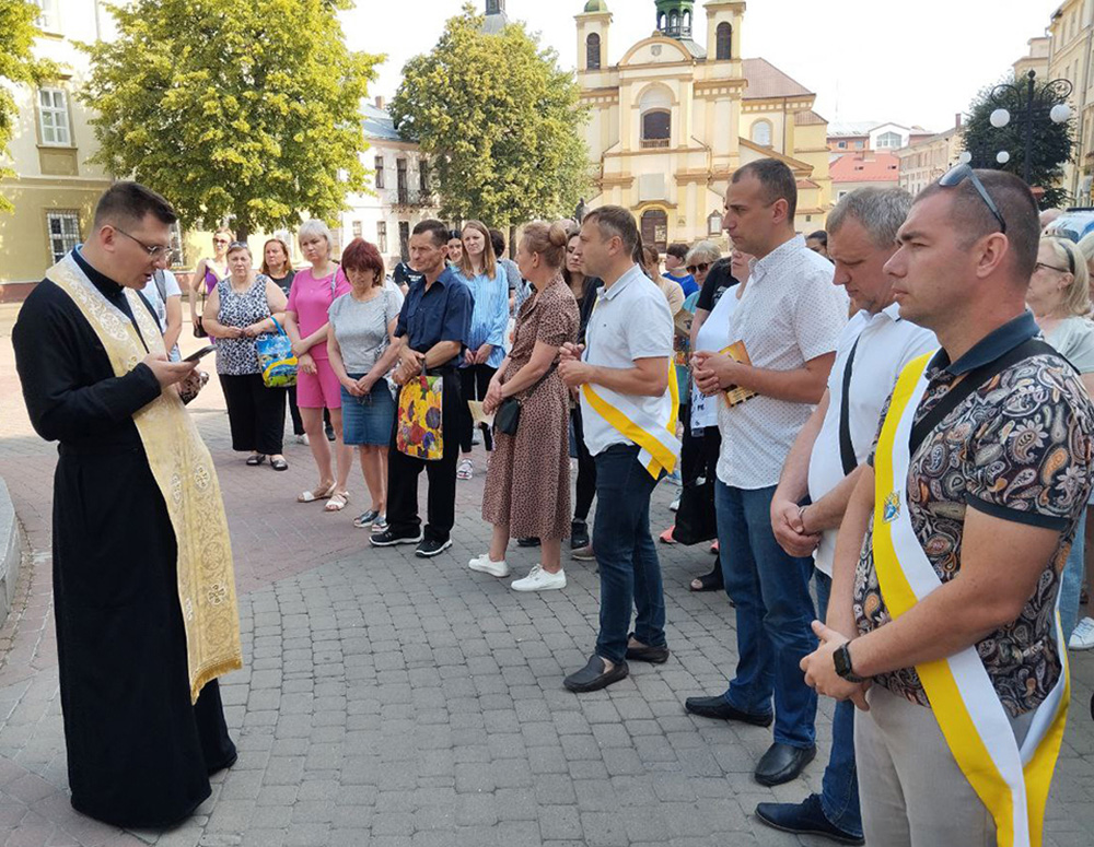 A priest leads a prayer outside.