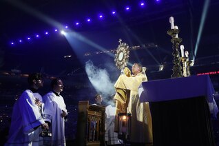 Bishop Andrew Cozzens of Crookston, Minn., blesses pilgrims during adoration at Lucas Oil Stadium in Indianapolis July 17, 2024.