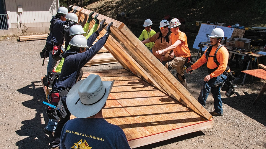 Santiago Catholic Trade School instructor Jeff Rice (foreground) oversees students constructing a confessional.