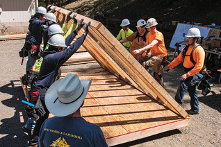 Santiago Catholic Trade School instructor Jeff Rice (foreground) oversees students constructing a confessional.