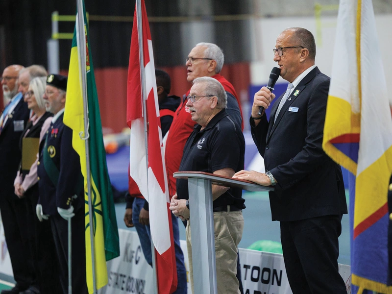 From right, Past State Deputy Larry Packet of Saskatchewan leads the Canadian national anthem, joined by Past Grand Knight Gil Wist of Denis Mahoney Council 8215, president of the Knights of Columbus Indoor Games planning committee; Richard Devon, a former district deputy; and others.