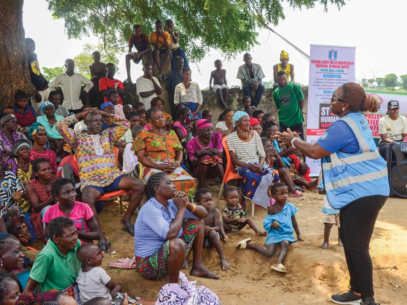 Residents of an IDP camp in Benue State, Nigeria, listen to a trafficking awareness presentation.