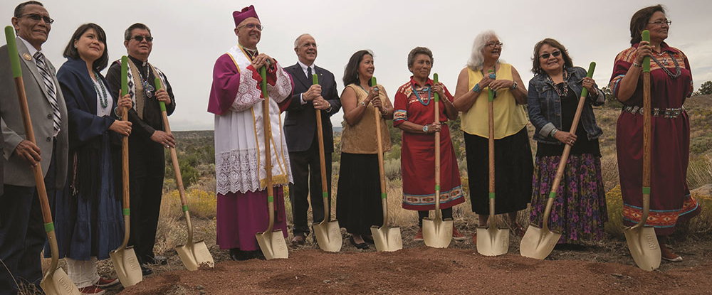 Men holding shovels in the dirt at a groundbreaking ceremony.