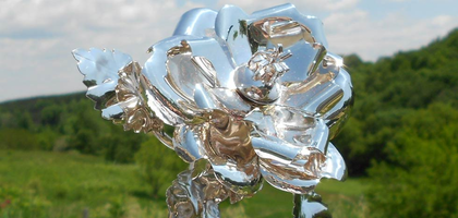 A Knight holding a silver rose with a white glove in a ceremony.