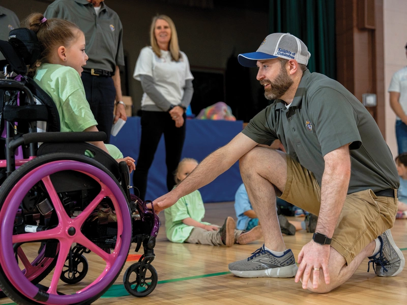 Philip Woodbury, a member of Council 428, greets a participant of the Special Olympics Young Athletes program