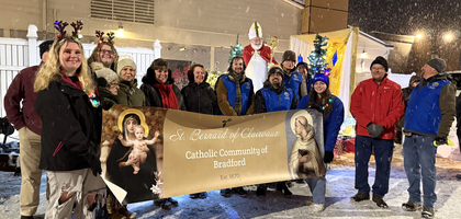 Knights from Bradford (Pa.) Council 403 and members of St. Bernard of Clairvaux Parish gather by the float sponsored by the parish in the city’s annual Christmas parade.