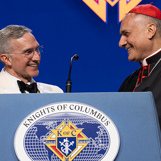 Supreme Knight Patrick Kelly welcomes Cardinal Mauro Gambetti to the podium at the States Dinner of the 142nd Supreme Convention on Aug. 6 in Québec City.