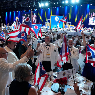 Delegates wave the Ohio flag as the state’s song is played during the annual States Dinner at the 142nd Supreme Convention in Québec Aug. 6.