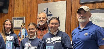Members of La Fourche Council 1114 in Thibodaux, La., present rosary booklets to Courtney Branson, religion teacher, and middle school students at St. Joseph Catholic Elementary School. The council donated 100 Our Blessed Mother’s Rosary booklets, featuring a Scripture verse for each Hail Mary, which are used in religion classes for grades five through seven.