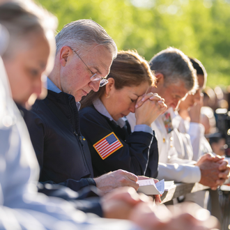 Supreme Knight Kelly and his wife, Vanessa, pray with other Warriors to Lourdes pilgrims during Mass at the Grotto. 